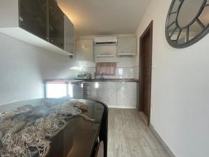 a kitchen with a glass counter and a clock on the wall at Studio Apartment Dona in Trogir