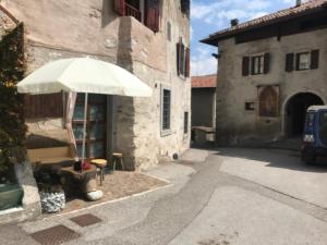 an umbrella in the courtyard of a building at B&B da Erica in Comano Terme