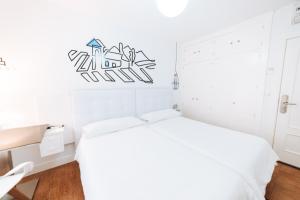 a white bedroom with a white bed in a room at Hostal Misericordia in León