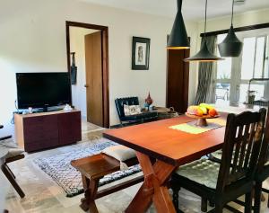 ein Wohnzimmer mit einem Holztisch und einem TV in der Unterkunft Theodora Hotel in Petra
