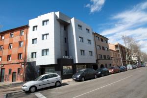 un coche blanco estacionado frente a un edificio en OKELO, en Zamora