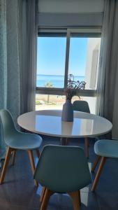 a table and chairs with a table and a window at Meandyou Marazul Lamanga in La Manga del Mar Menor
