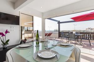 een eetkamer met een glazen tafel en een balkon bij Village Naturiste R4N - La Villa Rocca Luxe in Cap d'Agde