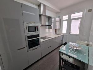 a kitchen with white cabinets and a stove top oven at Céntrico piso con patio y garaje in A Coruña