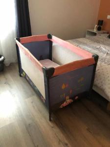 a toddler bed with a crib in a bedroom at Logement à Brive - proche de la gare et du centre ville - Climatisation - fibre internet - stationnements gratuits in Brive-la-Gaillarde