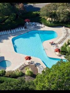 an overhead view of a large swimming pool with chairs at In the Heart of Harbour Town 2BR 2BA Pool Access Close to Beach in Hilton Head Island