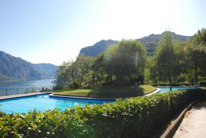 a swimming pool with a view of a river and mountains at La bella vista sul lago di Como in Valbrona