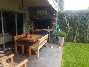 a wooden table and benches on a patio at Hermosa habitación en apartamento en Carrasco - Comparte Apartamento conmigo in Montevideo