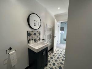 a bathroom with a sink and a mirror on the wall at Orchard Lodge -Coastal Retreat, new build, village views, private garden and terrace in Saint Brides Major