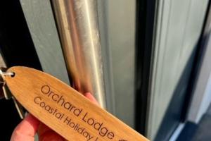 a person holding a wooden spoon with the words oakfield lodge cocktailhough at Orchard Lodge -Coastal Retreat, new build, village views, private garden and terrace in Saint Brides Major