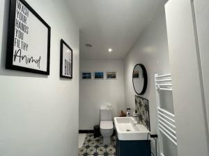a white bathroom with a sink and a toilet at Orchard Lodge -Coastal Retreat, new build, village views, private garden and terrace in Saint Brides Major