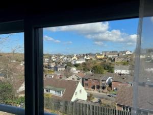 a view of a city from a window at Orchard Lodge -Coastal Retreat, new build, village views, private garden and terrace in Saint Brides Major