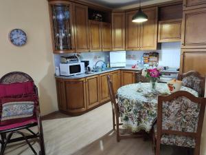 een keuken met een tafel met een vaas met bloemen erop bij Laku Apartment - At The Heart of Tirana in Tirana