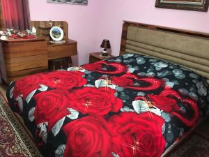 een slaapkamer met een bed met rode rozen erop bij Laku Apartment - At The Heart of Tirana in Tirana