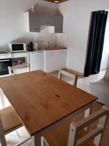 cocina con mesa de madera en una habitación en Giropode, maisonnette 36m2, 1/5 pers, cour fermée., en Chasseneuil-du-Poitou