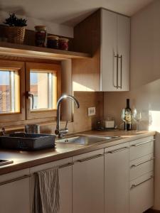 a kitchen with white cabinets and a sink at AS apartman 2 in Vršac