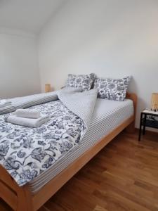 uma cama com lençóis e almofadas preto e branco em AS apartman 2 em Vršac