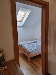 a door to a bedroom with a bed and a window at AS apartman 2 in Vršac