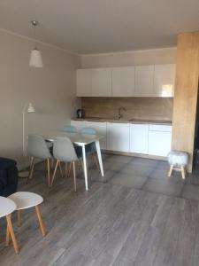 a kitchen and dining room with a table and chairs at Apartament 44 Pogo in Pogorzelica