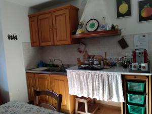 cocina con armarios de madera y encimera en Casetta Pasqualina, en Tavernelle