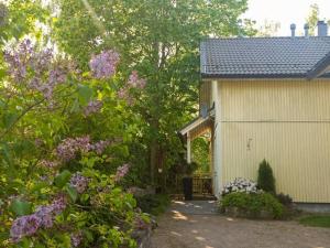 ein Haus mit einem Gebäude und einigen Bäumen und Blumen in der Unterkunft Cosy Loft in Helsinki