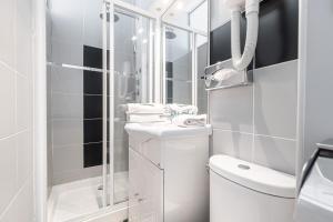 a bathroom with a toilet and a sink and a shower at Modern Waikiki Hotel in Cannes +61 photos