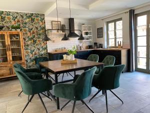 a dining room with a table and green chairs at Apartmenthaus Seiler in Quedlinburg