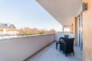 balkon ze stołem i krzesłami oraz widokiem w obiekcie Apartament Baltic Sun N°37 w Sztutowie