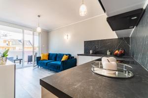 kuchnia i salon z niebieską kanapą w obiekcie Apartament Baltic Sun N°37 w Sztutowie
