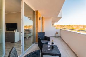 balkon ze stołem, krzesłami i telewizorem w obiekcie Apartament Baltic Sun N°37 w Sztutowie