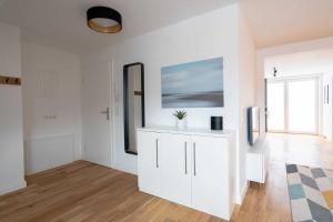 a white living room with a white refrigerator at LightHouse Whg 5 in Norderney