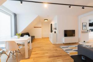 a living room with a white table and a tv at LightHouse Whg 5 in Norderney