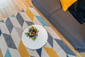 a white plate with a bouquet of flowers on a floor at LightHouse Whg 5 in Norderney