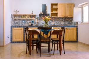 a kitchen with a table, chairs and a refrigerator at Le Terrazze di Pirandello in Agrigento