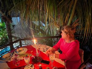 une femme assise à une table avec une bougie dans l'établissement Refugio Huasteco Hotel Boutique, à Tamasopo