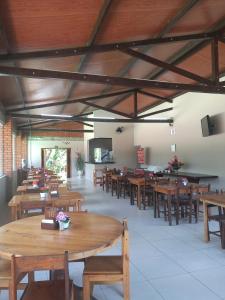 une salle à manger avec des tables et des chaises en bois dans l'établissement Pousada Scursel, à Ibirama