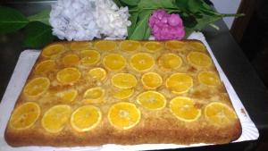 un pastel con naranjas encima de la mesa en Hotel el Rincon de Yaxu, en Vidiago