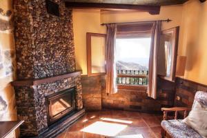 sala de estar con chimenea y ventana en Alojamientos Rurales Benarum con Spa, en Alpujarra de la Sierra