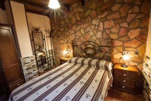 a bedroom with a bed in a stone wall at Alojamientos Rurales Benarum con Spa in Alpujarra de la Sierra