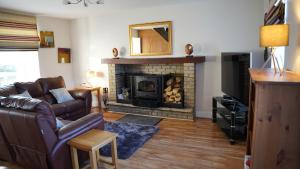 a living room with a couch and a fireplace at Connemara Farmhouse in Galway