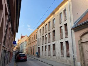 ulica z budynkami i samochód zaparkowany na ulicy w obiekcie Germar Apartman w mieście Pecz