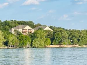 a house on the shore of a body of water at Table Rock Sunset Condo with Boat Slip in Branson