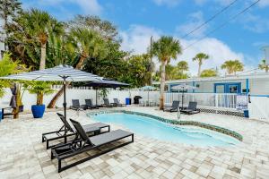 a swimming pool with lounge chairs and an umbrella at The Inn on Siesta Key in Siesta Key