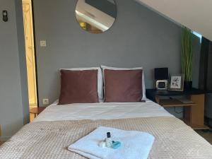 a bedroom with a bed with a towel on it at Mon Petit Orne Centre thermal Un-Séjour-à-Part in Rombas +9 photos