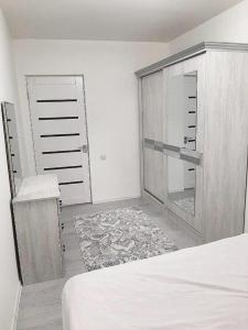 a bedroom with a bed and a closet and a door at Stylish 1-bedroom apartment near Atlas Mall & Ecobozor in Tashkent
