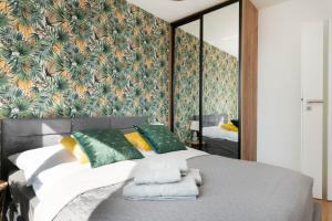 a bedroom with a large bed with green and yellow pillows at South4You Apartments in Wrocław