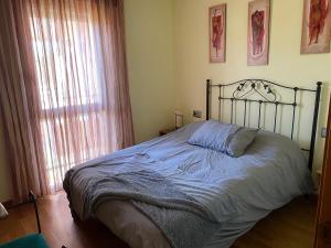 a bedroom with a bed and a window at SAN VICENTE DO MAR (URBANIZACIÓN PEDRAS NEGRAS) O GROVE- SANXENXO in O Grove