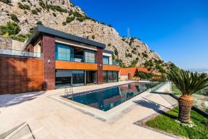 a house with a swimming pool in front of a mountain at ORIGINE RENTALS AN2 in Hurmaköy