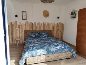 1 dormitorio con 1 cama y pared de madera en Aux d'Estaing Croisés, Gîte de montagne accessible à tous, en Estaing