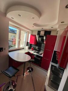 uma cozinha com armários vermelhos e uma mesa em LUXURY RED APARTMENT by Marta em Radom